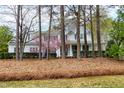 Beautiful home exterior showcased through mature trees and landscaping, with covered porch at 101 Goldenthal Ct, Cary, NC 27519