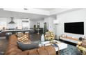 Open floorplan living room with hardwood floors, modern kitchen, comfortable seating, and lots of sunlight at 110 N Corcoran St # 2502, Durham, NC 27701