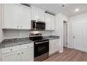 Well-equipped kitchen featuring stainless steel appliances, granite countertops, and white cabinets at 12 Crow Field St, Roxboro, NC 27574
