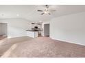 Living room with carpet flooring flows into the adjacent kitchen with white cabinetry at 12 Crow Field St, Roxboro, NC 27574