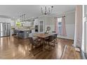 Elegant dining area with modern chandelier, hardwood floors, and open access to the kitchen at 1515 E Jones St, Raleigh, NC 27610