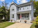 Charming two-story home with a welcoming front porch, red door, and landscaped front yard at 1515 E Jones St, Raleigh, NC 27610