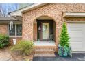 Charming front porch with brick archway, decorated with plants, and seasonal decor at 1525 Rogers Rd, Graham, NC 27253