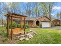 Charming brick home with an inviting front yard featuring a wooden swing and stone accents at 1525 Rogers Rd, Graham, NC 27253