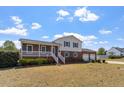 View of the home's exterior, featuring a two-story brick facade, porch, and large front yard at 153 Glenn Oak Dr, Sanford, NC 27332