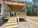 New deck under construction with wooden stairs and railing, nestled amongst mature trees at 1547 Pecan Drive # 31, Nashville, NC 27856