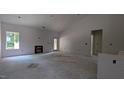 An unfinished living room with high ceilings, a fireplace frame, and a glass panel door at 1565 Pecan Drive # 30, Nashville, NC 27856