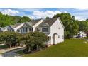 Charming two-story townhouse with a well-maintained front yard and inviting entrance with brick steps at 202 Wimbledon Ct, Clayton, NC 27520