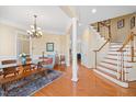 Bright dining room featuring hardwood floors, chandelier, and staircase with white railing at 2308 Carriage Oaks Dr, Raleigh, NC 27614