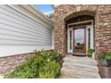 Close up of front door entryway, showcasing a stone archway and colorful potted flowers at 2554 Club Level Dr, Apex, NC 27523