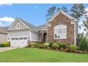 Charming single Gathering home featuring a stone facade, manicured lawn, and attached two car garage at 2554 Club Level Dr, Apex, NC 27523