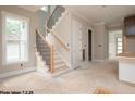 Bright hallway features stairs with dark metal railing and wood trim, leading to a light filled home interior at 2603 Vineyard St, Durham, NC 27707