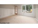 Unfinished living area with classic paneling and a large window providing natural light at 2603 Vineyard St, Durham, NC 27707