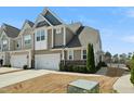 Two-story townhome featuring a two car garage, neutral siding, stone accents and landscaping at 310 Shale Creek Dr, Durham, NC 27703