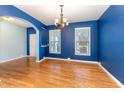 Bright dining room featuring hardwood floors, blue walls, and a classic chandelier for elegant meals at 318 Sylvias Ct, Durham, NC 27703