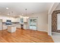 Spacious kitchen with white cabinets, island, stainless steel appliances, and hardwood floors at 318 Sylvias Ct, Durham, NC 27703