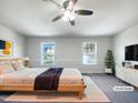 Bedroom features a bed, neutral color scheme, carpeted floors, and bright double windows. (Virtually Staged) at 350 Gilman Ln # 104, Raleigh, NC 27610