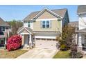Home exterior with two car garage and welcoming front porch, with a small, blooming tree at 36 Labradoodle Ct, Garner, NC 27529