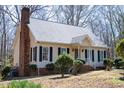 Exterior view of a well-maintained home with vinyl siding, a brick chimney, and mature trees at 401 Joyce Rd, Hillsborough, NC 27278