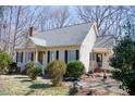 A charming home featuring a front porch with black shutters and complemented by mature trees at 401 Joyce Rd, Hillsborough, NC 27278