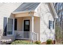 Home entrance featuring a side porch, white railing, and black door with black shutters at 401 Joyce Rd, Hillsborough, NC 27278