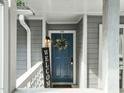 Charming front door with a wreath, welcome sign, and overhead lighting at 4601 Timbermill Ct # 302, Raleigh, NC 27612