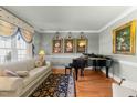 Cozy living room featuring a sofa, grand piano, and decorative artwork at 749 Hadrian Dr, Garner, NC 27529