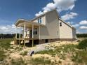 Rear view of a home under construction with covered porch and wood deck stair supports at 85 Prency Ln, Middlesex, NC 27557