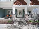 Inviting front porch with stone supports, seating, and decorative wreath on the front door at 904 Hidden Jewel Ln, Wake Forest, NC 27587