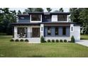 Beautifully designed modern home with a stone facade, sleek lines, and professional landscaping showcases contemporary style at 95 Cherry Bark Dr, Youngsville, NC 27596