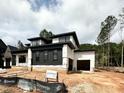 Contemporary home with black and white facade, showcasing its unique architectural design and garage at 95 Cherry Bark Dr, Youngsville, NC 27596