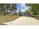 Gray single-story home with attached two car garage, driveway, and lawn at 1 Greenfield Ct, Durham, NC 27705