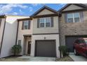 Charming townhome featuring a one-car garage, shutters, and a combination of siding and brick at 102 Bella Pl, Holly Springs, NC 27540