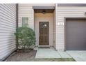 Close-up view of the townhome's front door and entryway with a small window at 102 Bella Pl, Holly Springs, NC 27540