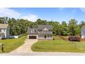Inviting home featuring a well-manicured lawn, blacktop driveway, and a charming front porch at 112 Roping Horn Way, Willow Springs, NC 27592