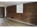 Finished basement with a painted brick wall, a built-in shelf and wood-look flooring at 1212 St. Marys Rd, Hillsborough, NC 27278