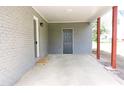 View of attached carport, featuring brick columns, a concrete floor, and a side door at 1212 St. Marys Rd, Hillsborough, NC 27278