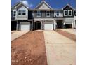 New construction townhomes feature stone accents, covered entrances, and individual garages at 1243 Hammond Dr, Mebane, NC 27302