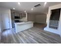 Open-concept kitchen with island, stainless appliances, and wood-look flooring in living area at 1243 Hammond Dr, Mebane, NC 27302
