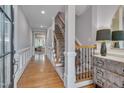 Elegant entryway with hardwood floors, staircase with rod iron railing, and decorative wainscoting at 129 Cofield Cir, Durham, NC 27707