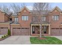 Charming brick townhome with a well-manicured lawn, inviting front porch, and a two-car garage at 129 Cofield Cir, Durham, NC 27707