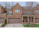 Attractive red brick townhome showcasing a two-car garage and cozy front porch at 129 Cofield Cir, Durham, NC 27707