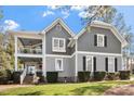 Charming gray home with white trim, covered front porch and manicured landscaping at 1300 Marshall Farm St, Wake Forest, NC 27587