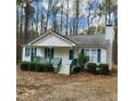 Inviting one-story house boasts a covered front porch and blue shutters nestled among mature trees at 132 Waiters Way Way, Youngsville, NC 27596