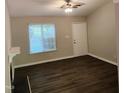 Neutral living room featuring wood-look flooring, a ceiling fan, and a white entry door at 132 Waiters Way Way, Youngsville, NC 27596