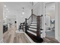 Elegant curved staircase with dark wood treads and a view into the adjacent bathroom at 1332 Gloriosa St, Apex, NC 27523