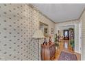 Foyer with wallpaper, hardwood floors, and decorative accents leading into the home's interior at 1410 Briardale Ln, Durham, NC 27712