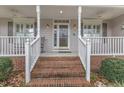 Inviting front porch with brick steps, white railings, and sidelights highlighting the home's entrance at 1410 Briardale Ln, Durham, NC 27712