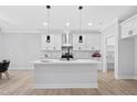 A bright kitchen featuring an island with a sink, white cabinets, and pendant lighting at 1429 Sagamore Dr, Louisburg, NC 27549