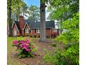 Traditional brick home with a chimney, flowering shrubs, and a landscaped yard at 1522 W Thomas St, Rocky Mount, NC 27804